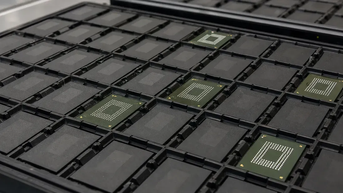 BGA memory packages in a compartmented tray, some showing their solder-ball grids