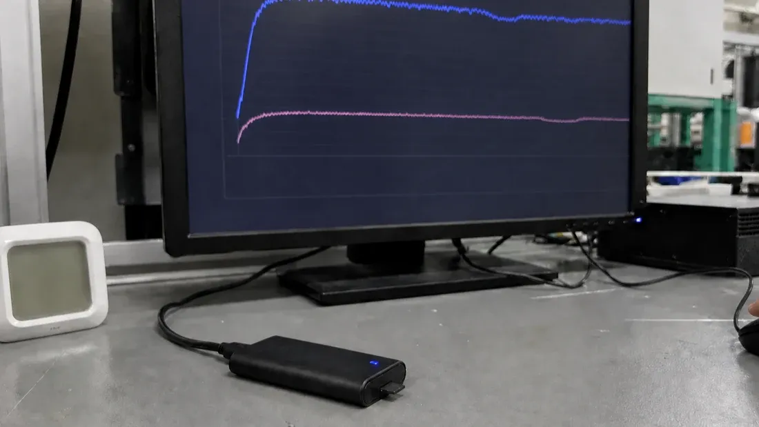 Factory quality workstation recording a long-duration microSD write-speed curve through a dedicated card reader